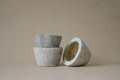 Three stone bowls of different sizes on a beige background