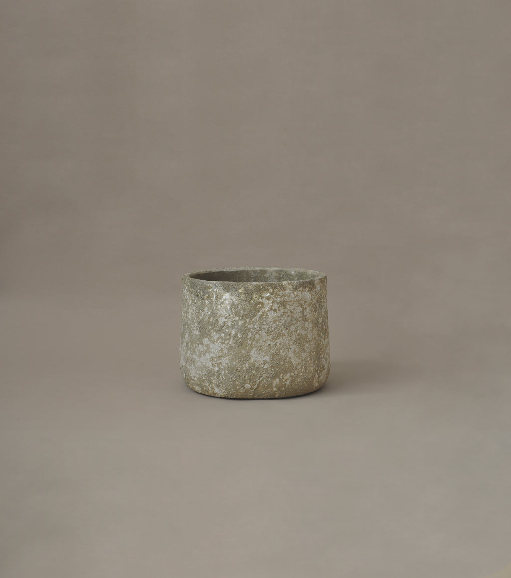 Textured ceramic pot on a brown background