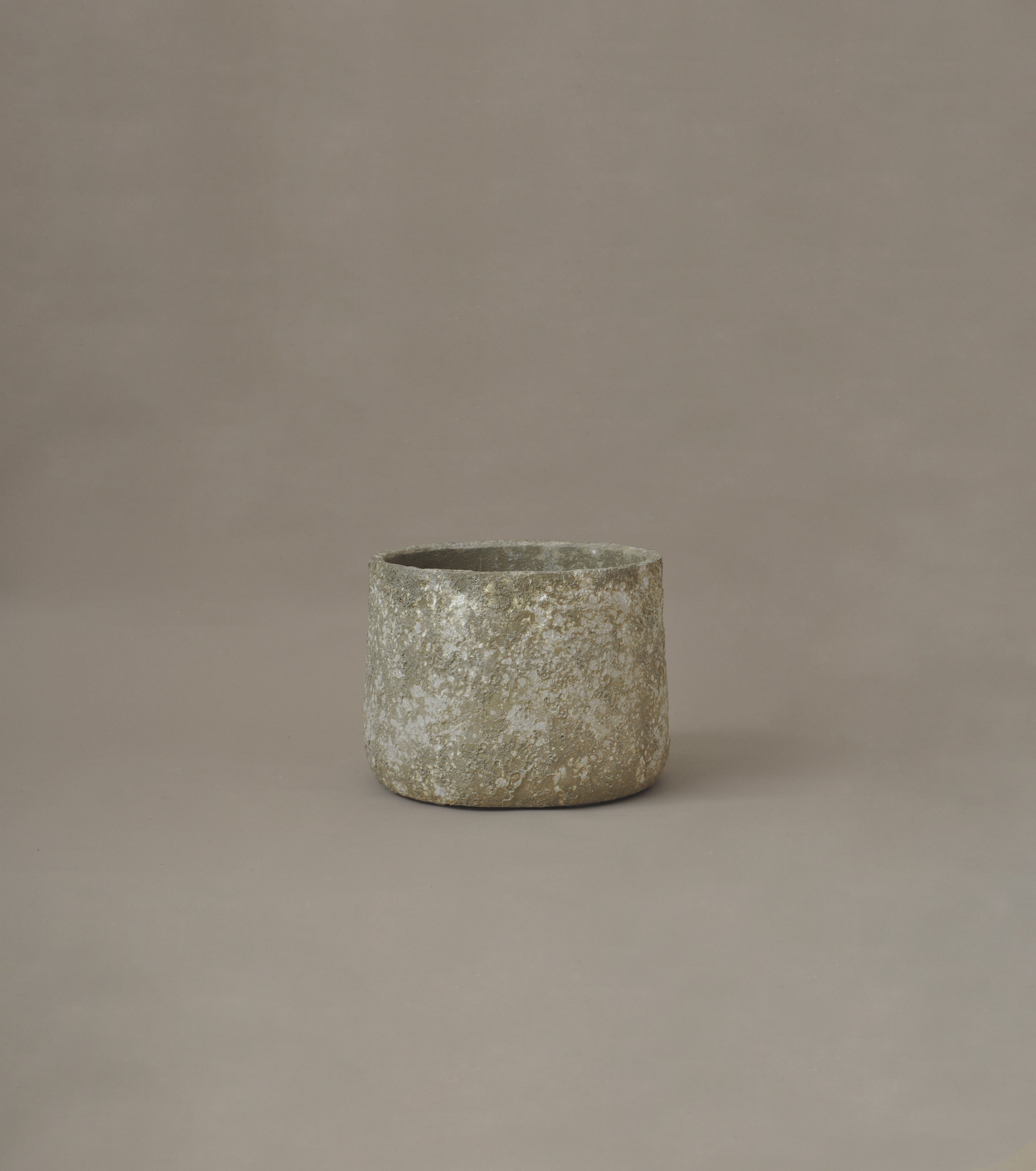 Textured ceramic pot on a brown background