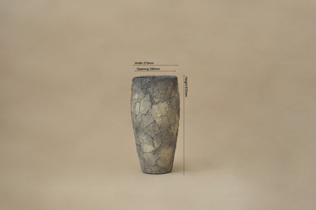 Cylindrical stone object with measurement labels on a beige background